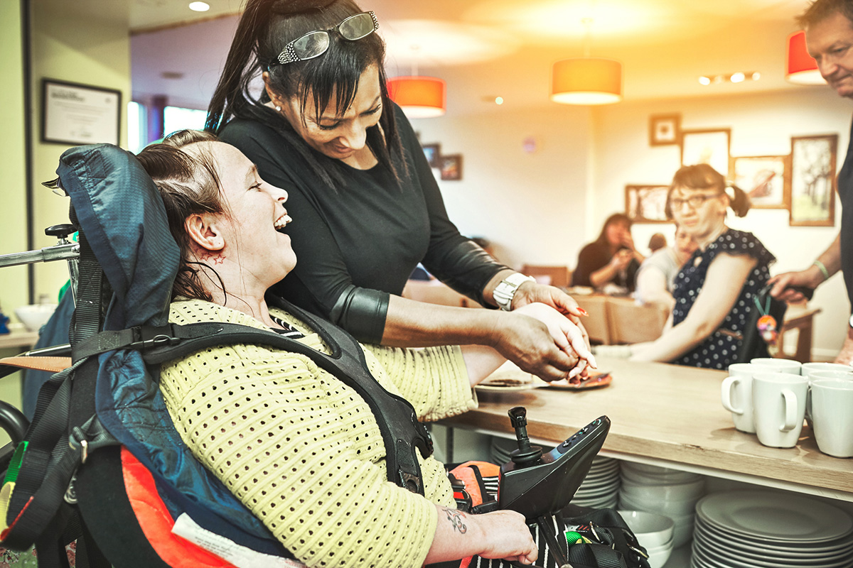 Complex needs Wheelchair Down Syndrome Disability Girl Patient In Clinic Or Hospital With Nurse Or Professional Healthcare Worker Nursing And Medical Caregiver Helping Happy Friendly And Young Disabled Person