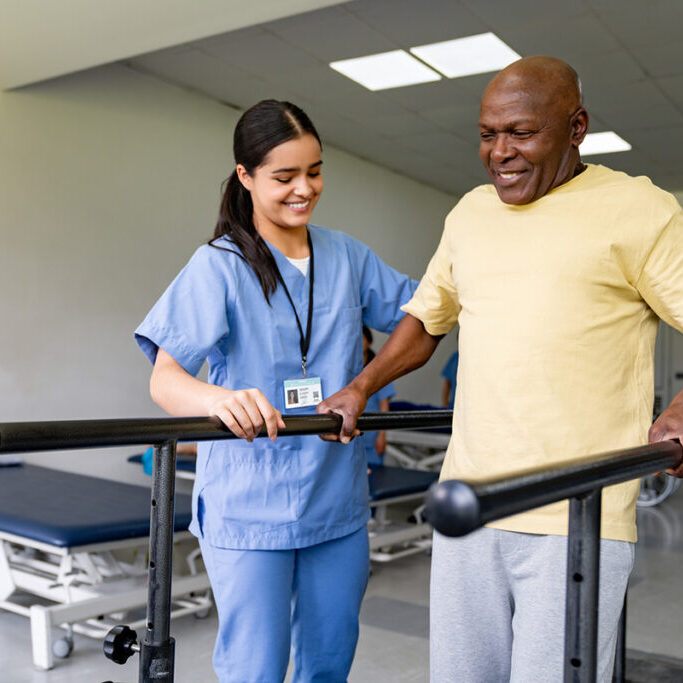 Physical Therapist Helping A Senior Man Walking On Bars